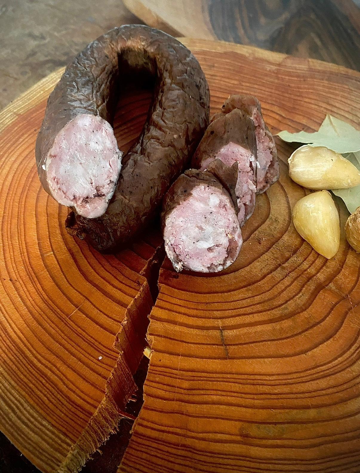 Wędzona kiełbasa zwinięta w krąg, przekrojona na plastry